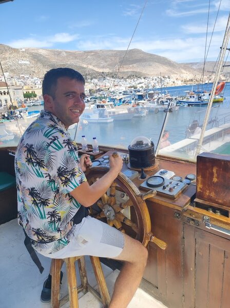 Buitenhof Reizen - Ondernemend - Griekse gezelligheid op Kos - begeleide groepsreizen voor mensen met een verstandelijke beperking - reiziger aan het roer van een boot Buitenhof Reizen - Ondernemend - Griekse gezelligheid op Kos - begeleide groepsreizen voor mensen met een verstandelijke beperking - reiziger aan het roer van een boot