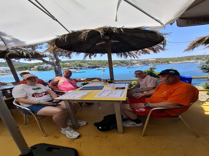 Buitenhof Reizen voor mensen met een verstandelijke beperking - Ondernemend - Feesten op Ibiza - reizigers aan tafel met uitzicht op het water