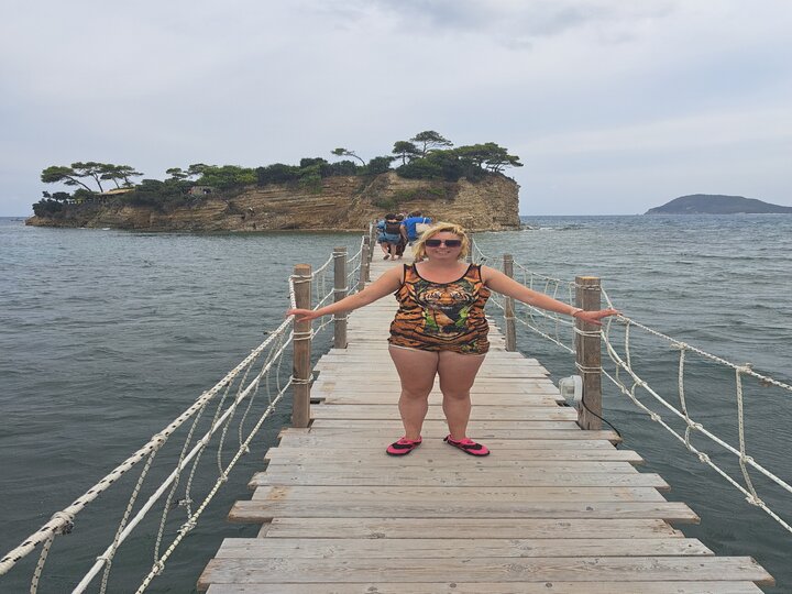 Buitenhof Reizen - Jongeren-Zonnig Zakynthos - begeleide groepsreizen voor mensen met een verstandelijke beperking - reiziger op loopbrug bij de zee Buitenhof Reizen - Jongeren-Zonnig Zakynthos - begeleide groepsreizen voor mensen met een verstandelijke beperking - reiziger op loopbrug bij de zee