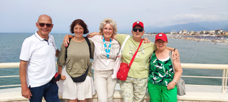 Buitenhof Reizen - Toscane - begeleide vakanties voor mensen met een verstandelijke beperking - Groepsfoto met zee Buitenhof Reizen - Toscane - begeleide vakanties voor mensen met een verstandelijke beperking - Groepsfoto met zee