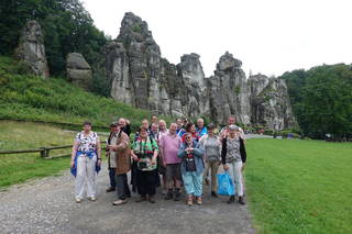 Buitenhof Reizen voor mensen met een verstandelijke beperking - Ondernemend - Natuur in Willebadessen - groepsfoto in natuur met rotsen op achtergrond Buitenhof Reizen voor mensen met een verstandelijke beperking - Ondernemend - Natuur in Willebadessen - groepsfoto in natuur met rotsen op achtergrond