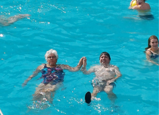 Buitenhof Reizen voor mensen met een verstandelijke beperking - Rustig Aan - Groen en natuur op Corfu - mensen hand in hand liggend in het zwembad Buitenhof Reizen voor mensen met een verstandelijke beperking - Rustig Aan - Groen en natuur op Corfu - mensen hand in hand liggend in het zwembad