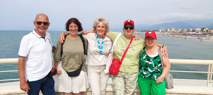 Buitenhof Reizen - Toscane - begeleide vakanties voor mensen met een verstandelijke beperking - Groepsfoto met zee Buitenhof Reizen - Toscane - begeleide vakanties voor mensen met een verstandelijke beperking - Groepsfoto met zee