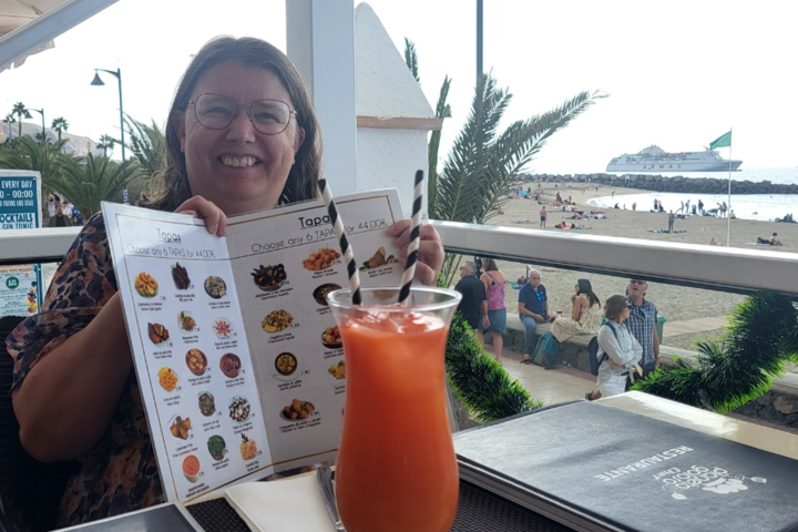 Buitenhof Reizen - Kerst op Tenerife - begeleide groepsreizen met een verstandelijke beperking - reiziger met kaart en cocktail Buitenhof Reizen - Kerst op Tenerife - begeleide groepsreizen met een verstandelijke beperking - reiziger met kaart en cocktail