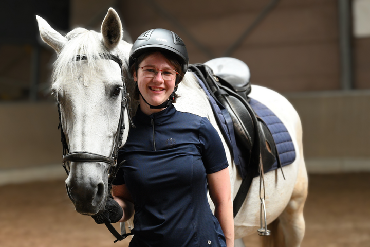 Buitenhof Reizen voor mensen met een verstandelijke beperking - Avontuurlijk - Woudenberg - Blije reiziger bij een paard in bak Buitenhof Reizen voor mensen met een verstandelijke beperking - Avontuurlijk - Woudenberg - Blije reiziger bij een paard in bak