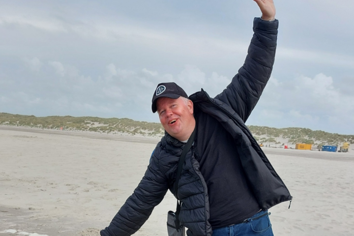 Buitenhof Reizen voor mensen met een verstandelijke beperking - Jongeren - Genieten op Terschelling - reiziger met handen in de lucht op het strand Buitenhof Reizen voor mensen met een verstandelijke beperking - Jongeren - Genieten op Terschelling - reiziger met handen in de lucht op het strand