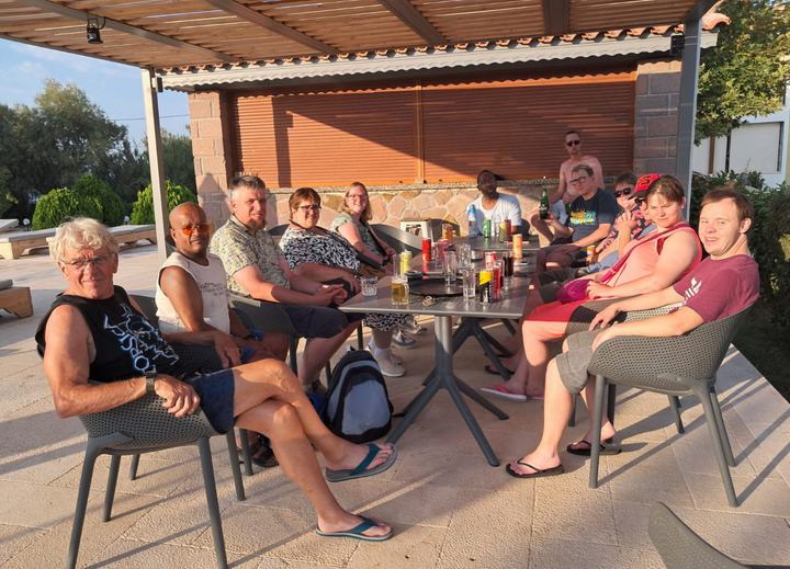 Buitenhof Reizen voor mensen met een verstandelijke beperking - Ondernemend - Vulkanisch Lesbos - groep reizigers op terras met wat drinken Buitenhof Reizen voor mensen met een verstandelijke beperking - Ondernemend - Vulkanisch Lesbos - groep reizigers op terras met wat drinken