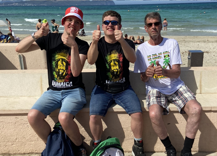 Buitenhof Reizen voor mensen met een verstandelijke beperking - Ondernemend - Zon, zee, strand op Mallorca - Drie reizigers op een bankje voor het strand Buitenhof Reizen voor mensen met een verstandelijke beperking - Ondernemend - Zon, zee, strand op Mallorca - Drie reizigers op een bankje voor het strand