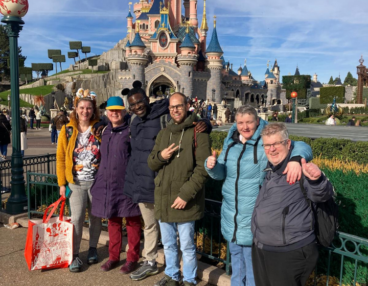 Buitenhof Reizen voor mensen met een verstandelijke beperking - magisch disneyland; grote bus - groepsfoto voor het kasteel